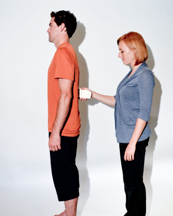 A man and a woman standing next to each other, measuring their physical abilities using the microFET®3 inclinometer.