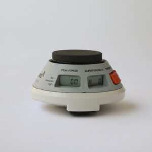 A digital timer sitting on a white surface, surrounded by medical dynamometers.
